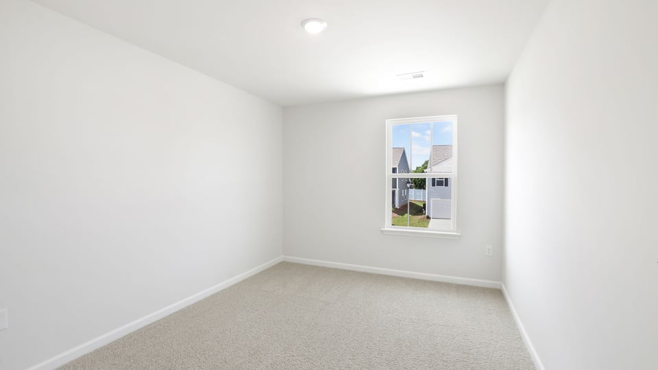 Bedroom with carpet and window.