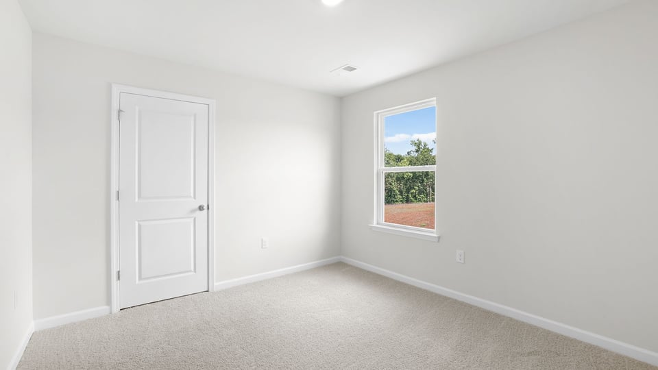 Bedroom with carpet and window.