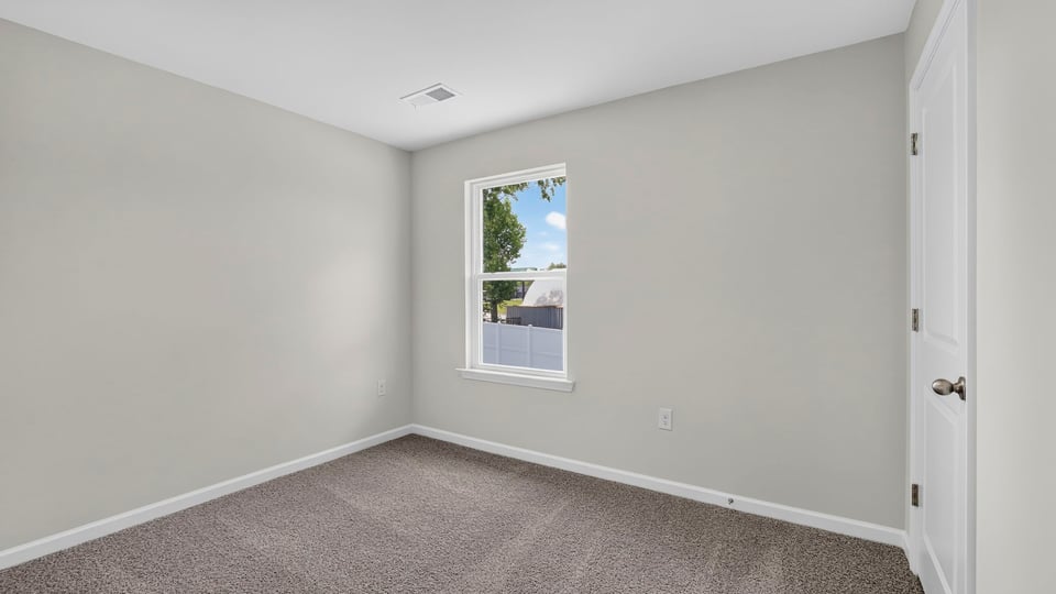 Bedroom with carpet and window.