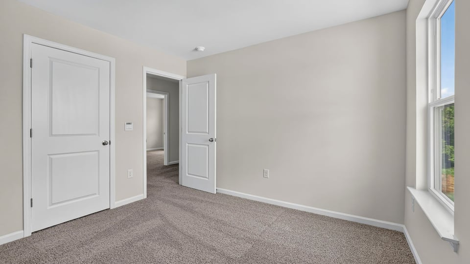 Bedroom with carpet and window.