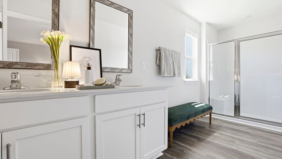 Bathroom with double vanity sink and walk in shower.