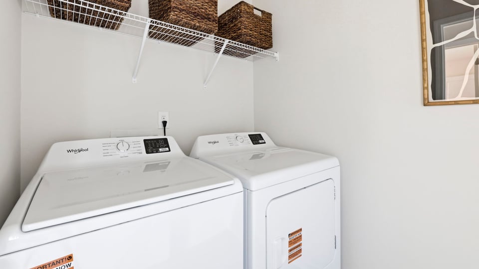 Laundry room with hanging storage racks.
