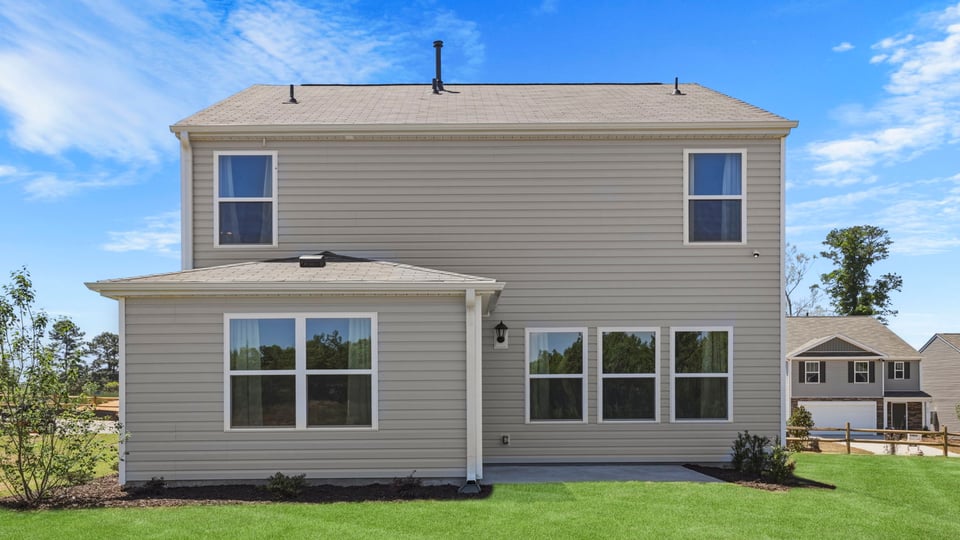 Back exterior of home with large backyard.