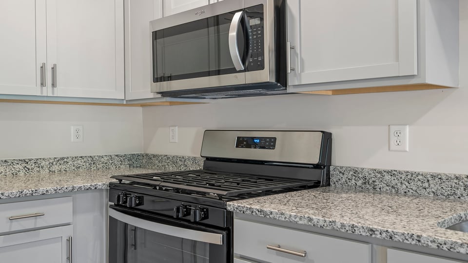Kitchen with granite countertops and gas range.