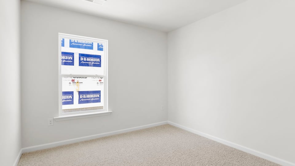 Bedroom with carpet and window.