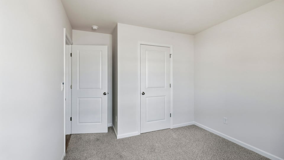 Bedroom with carpet and windows.