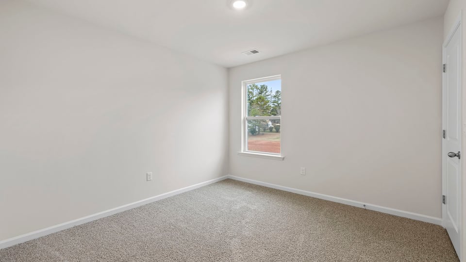 Bedroom with window and carpet.
