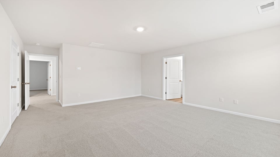 Primary bedroom with carpet.