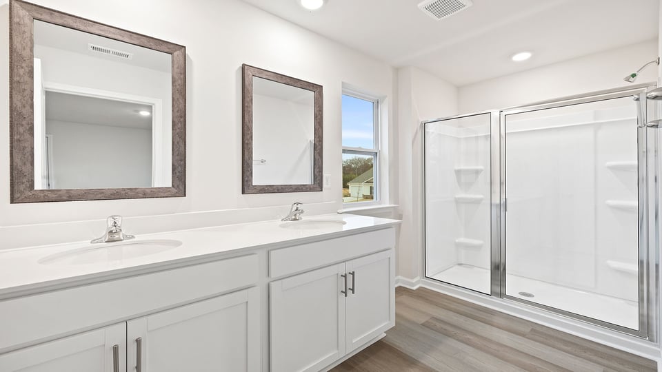 Primary bathroom with dual sink vanity and walk-in shower.