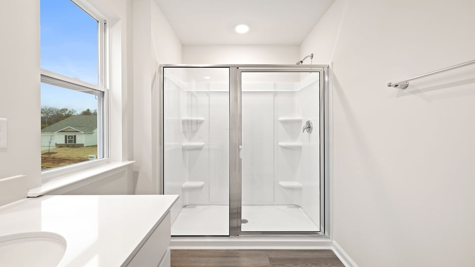 Primary bathroom with large window and walk-in shower.