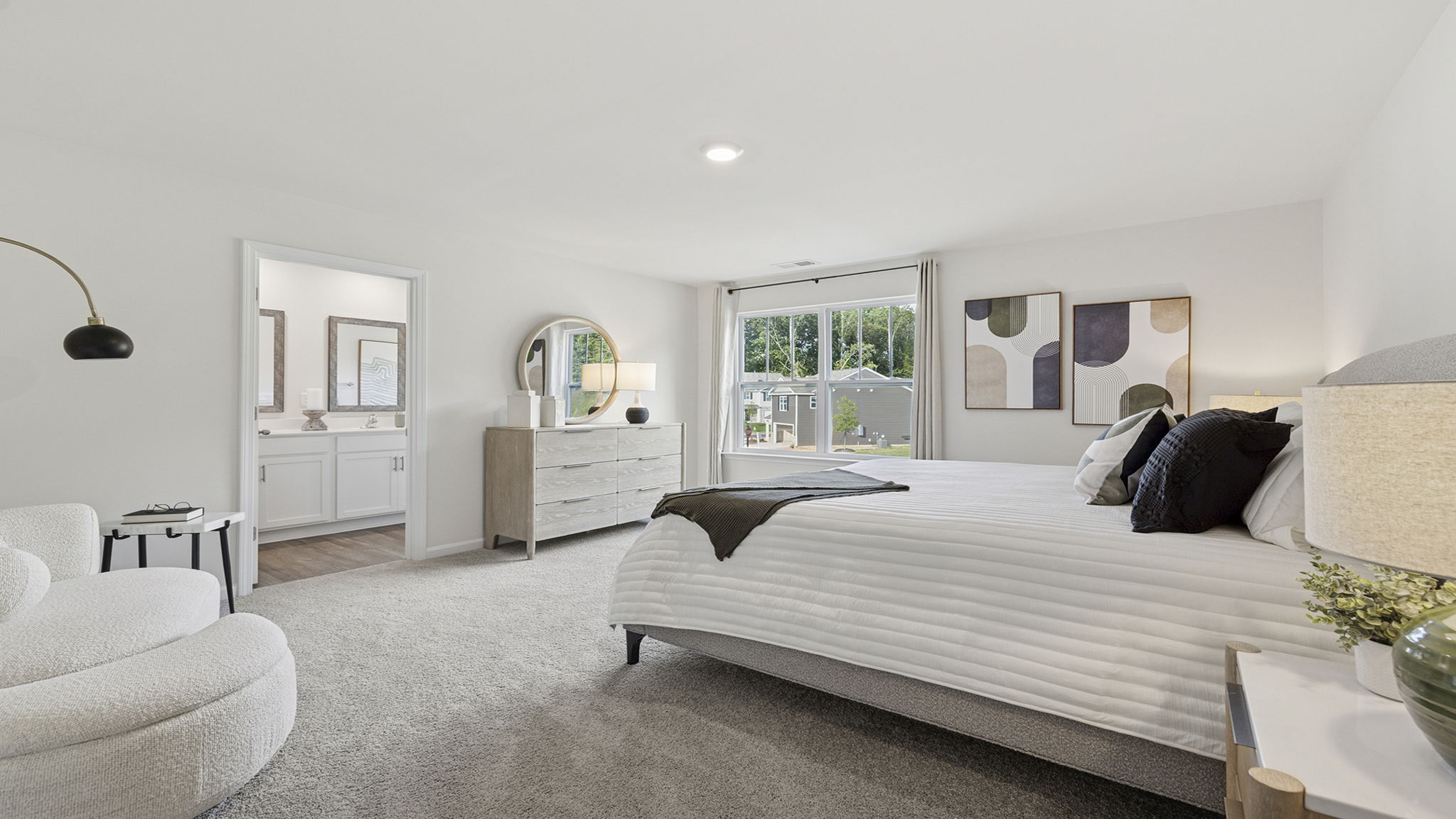 Primary bedroom with large window and carpet.
