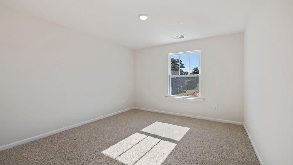 Bedroom with window and carpet.