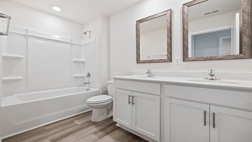 Hall bathroom with dual sink vanities.