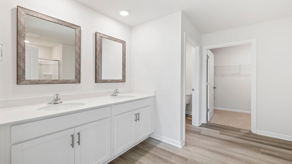 Primary bathroom with dual sink vanities and mirrors.