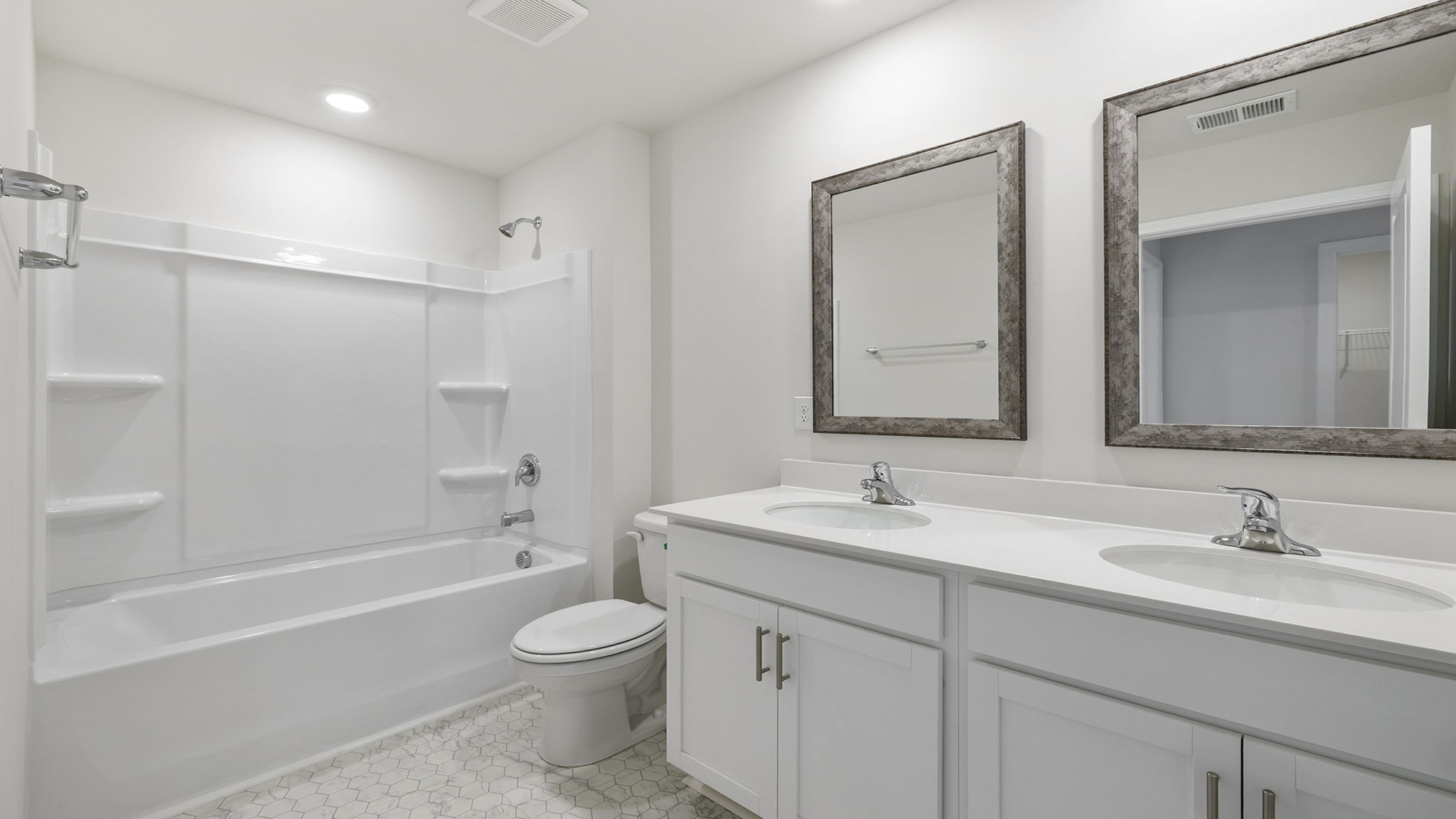 Hall bathroom with dual sink vanity and shower / tub.