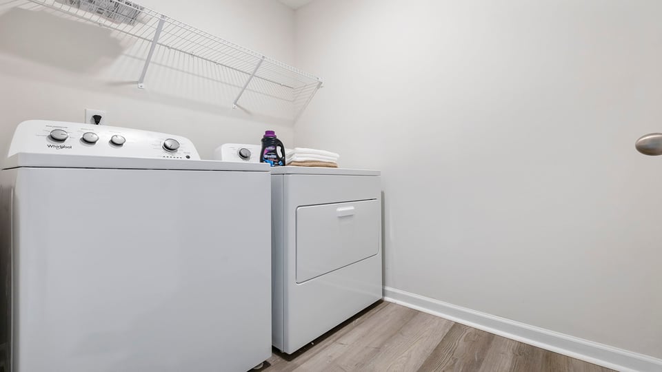 Laundry room with hanging storage racks.