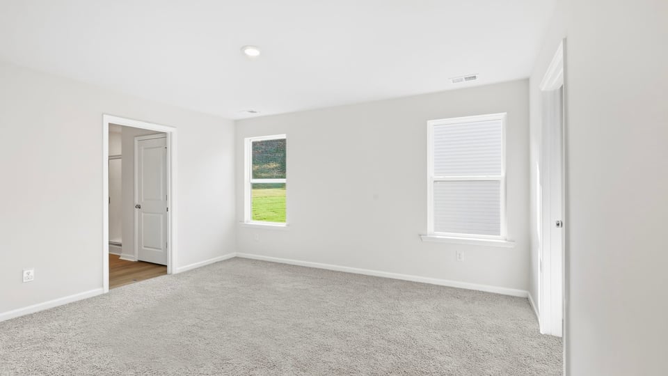 Bedroom with carpet and windows.