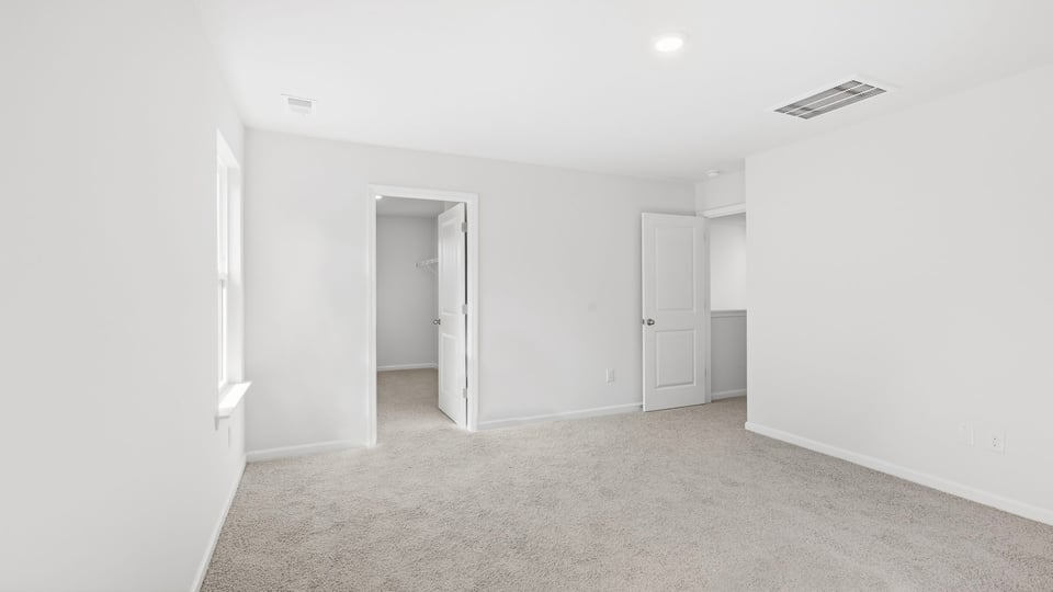 Bedroom with carpet and windows.