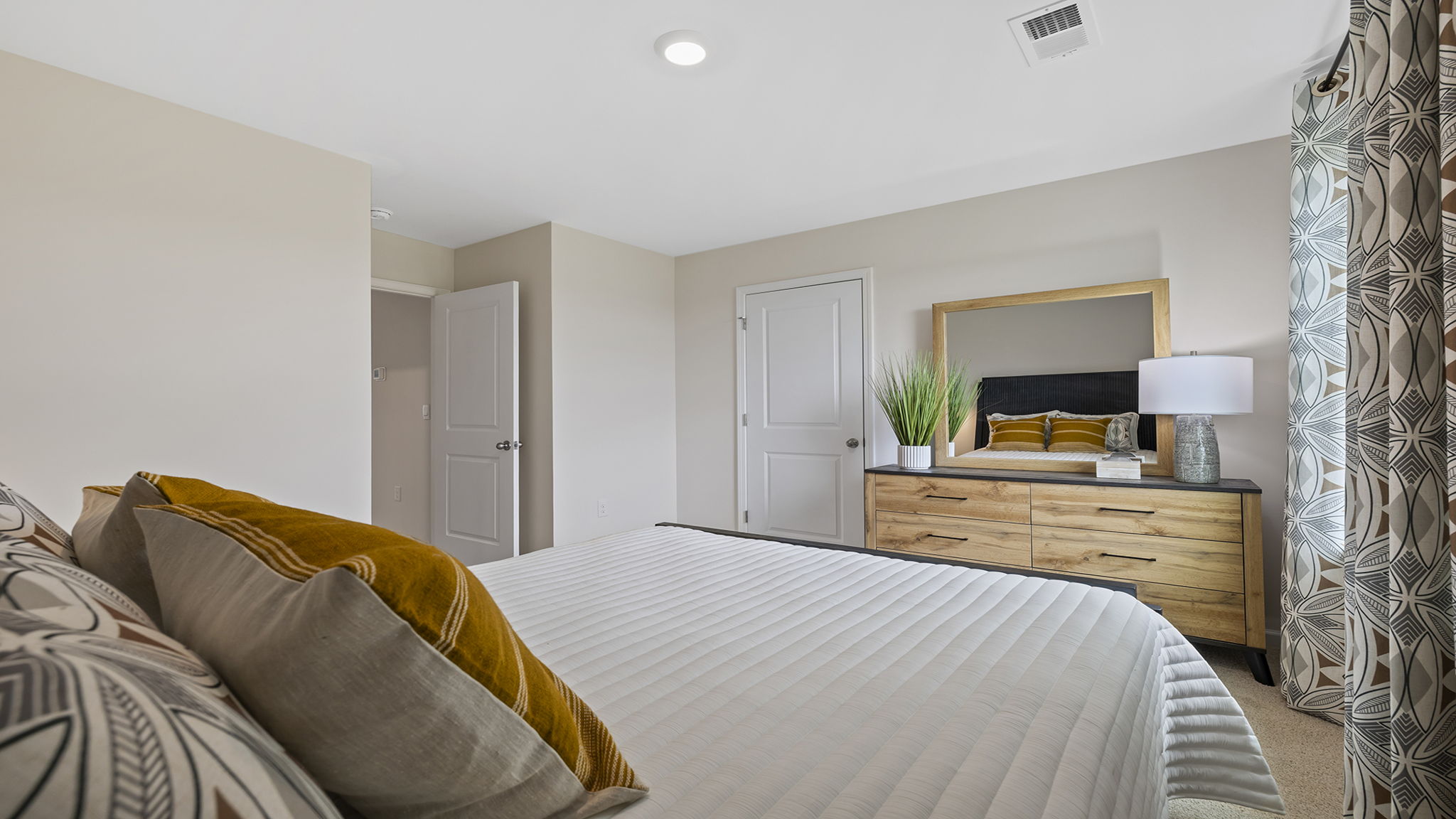 Primary bedroom with carpet and window.