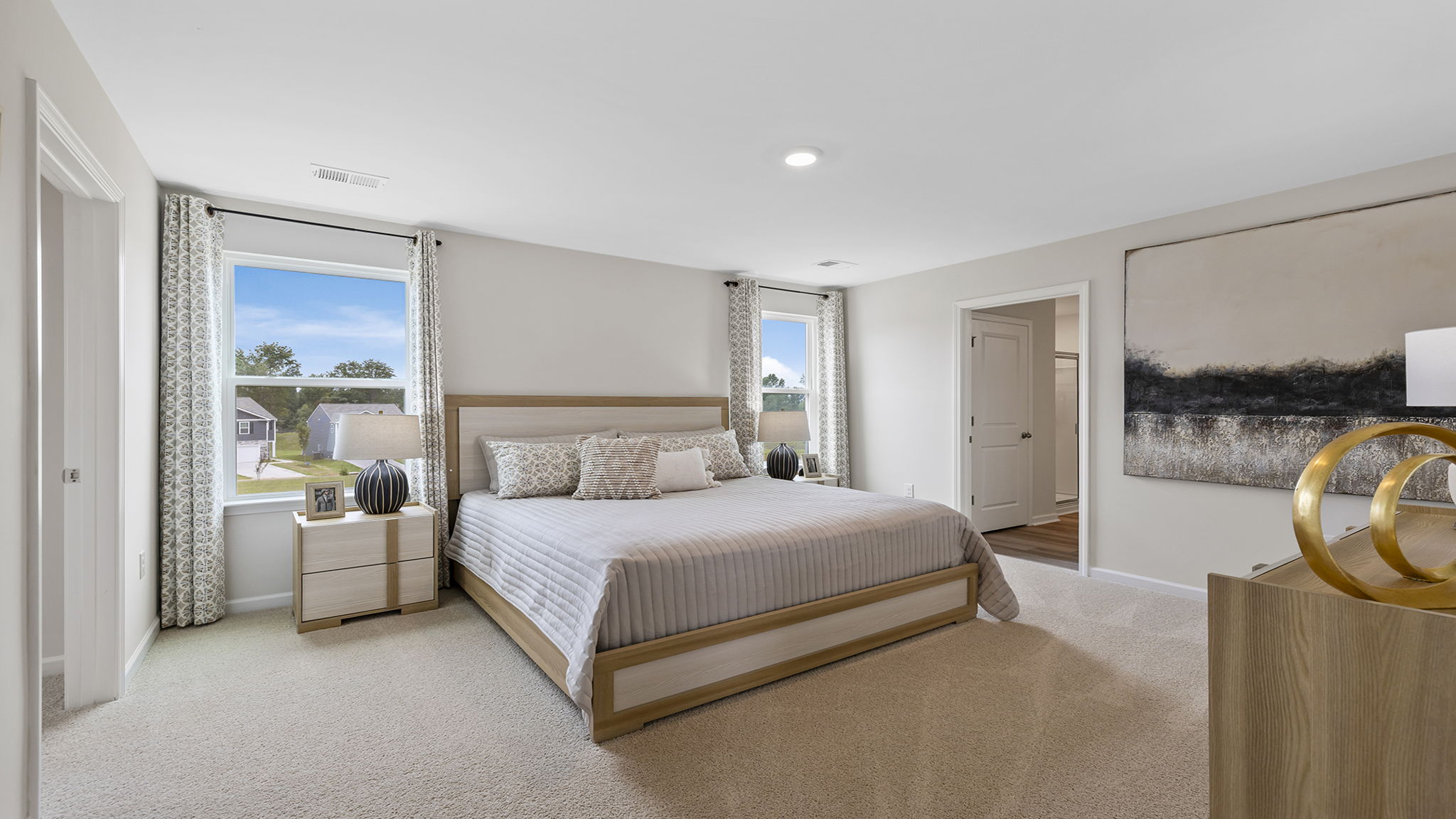 Primary bedroom with carpet and window.