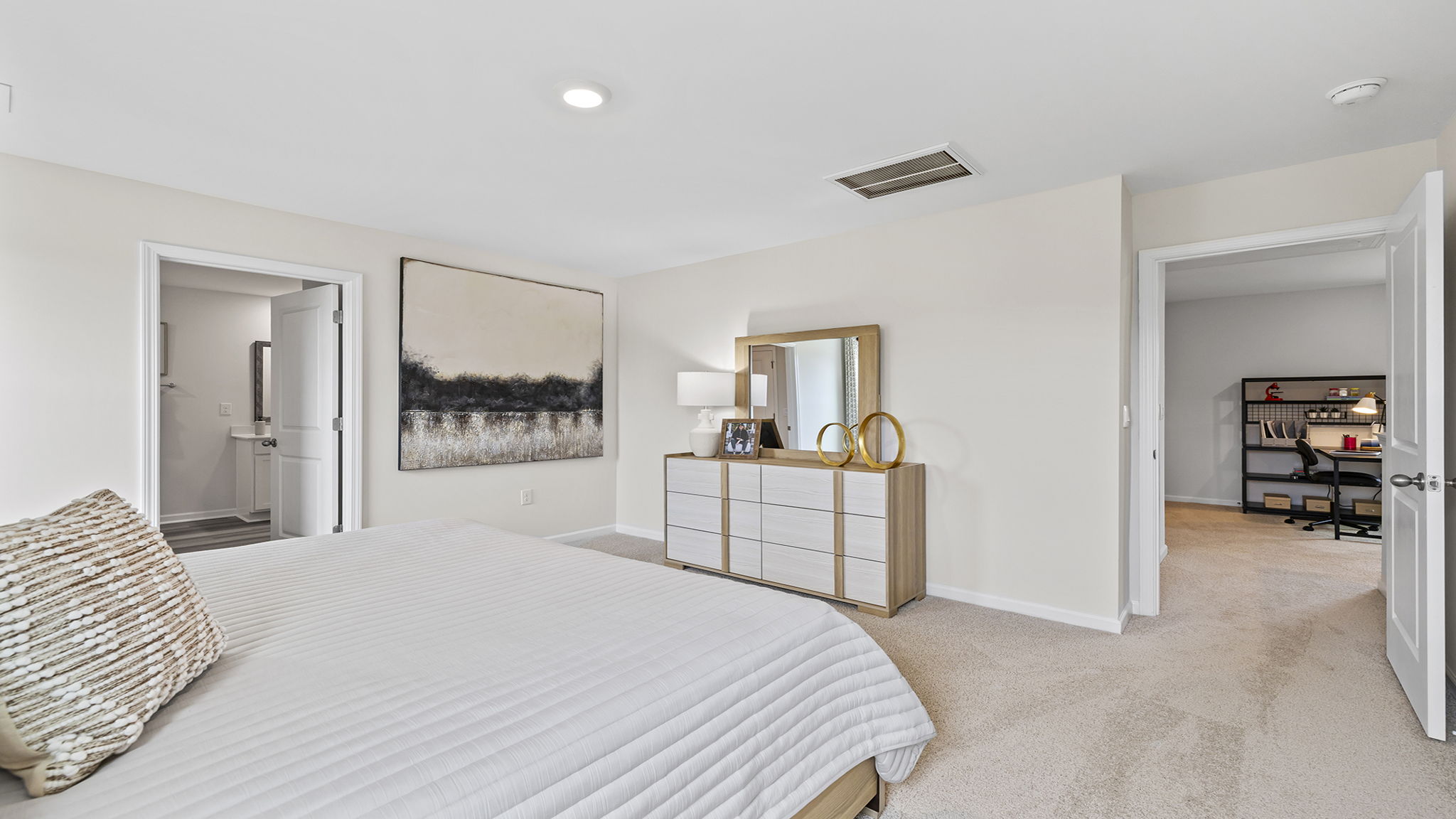 Primary bedroom with carpet and window.