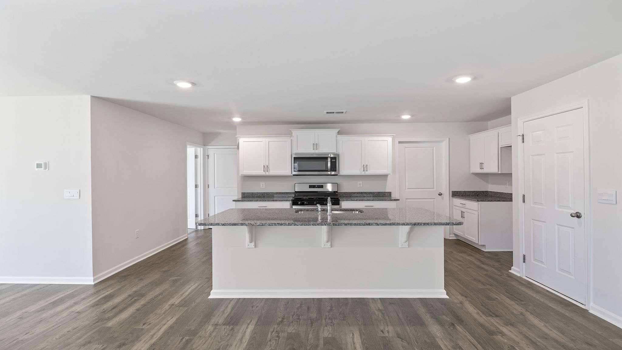 Large kitchen with island and white cabinetry.