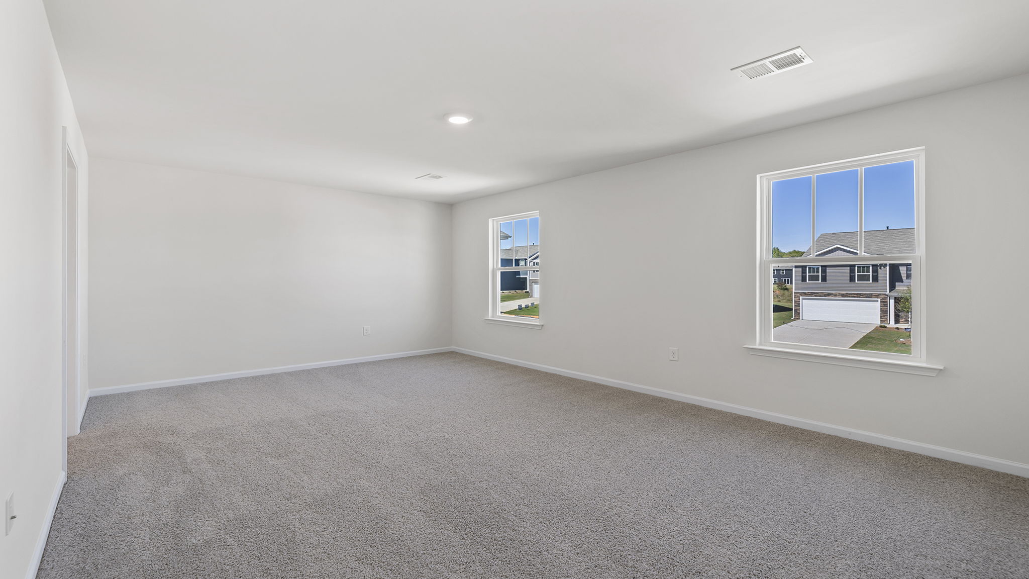Primary bedroom with large windows.