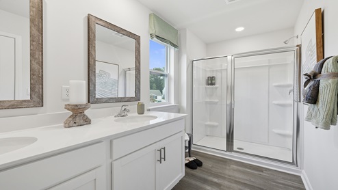 Primary bathroom with double vanity sinks and shower.