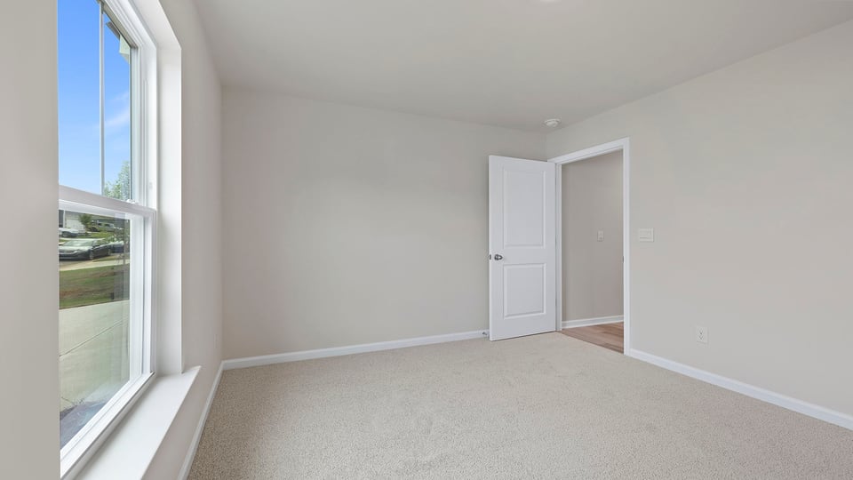 Bedroom with carpet and windows.