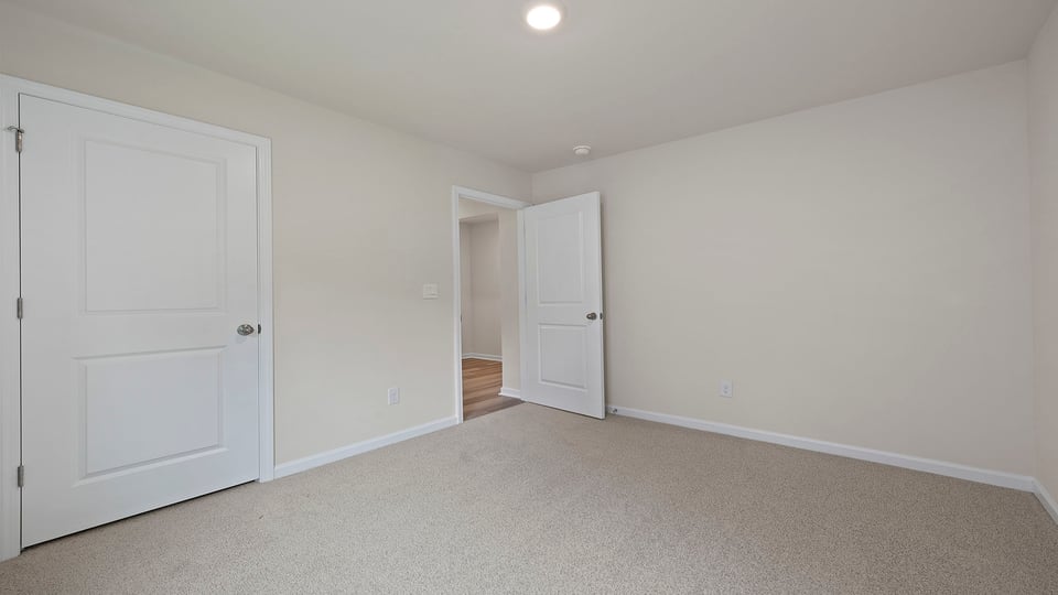 Bedroom with carpet and windows.