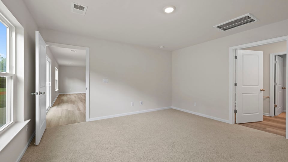 Bedroom with carpet and windows.