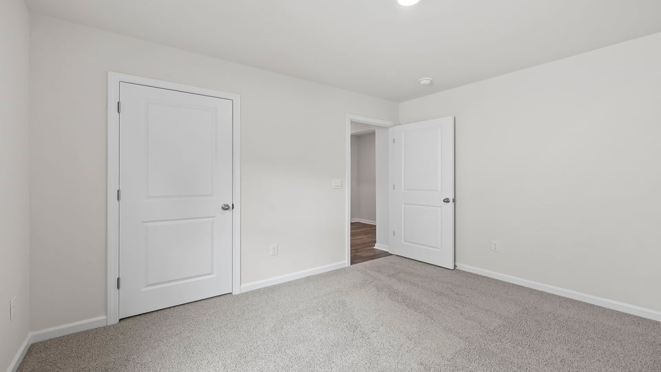 Bedroom with carpet and window.