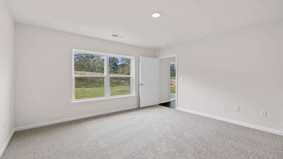 Bedroom with carpet and window.