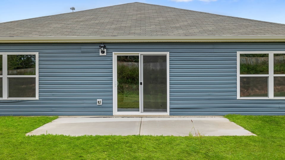 Back exterior of home with large backyard.