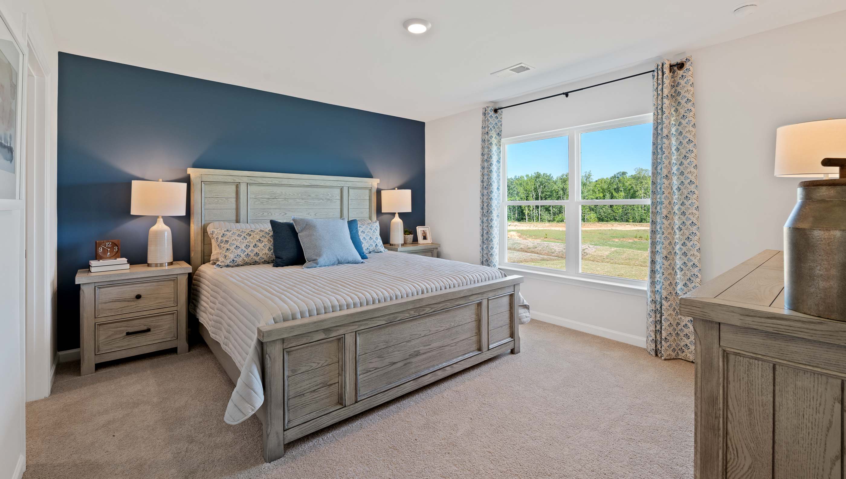 Primary bedroom with carpet and window.
