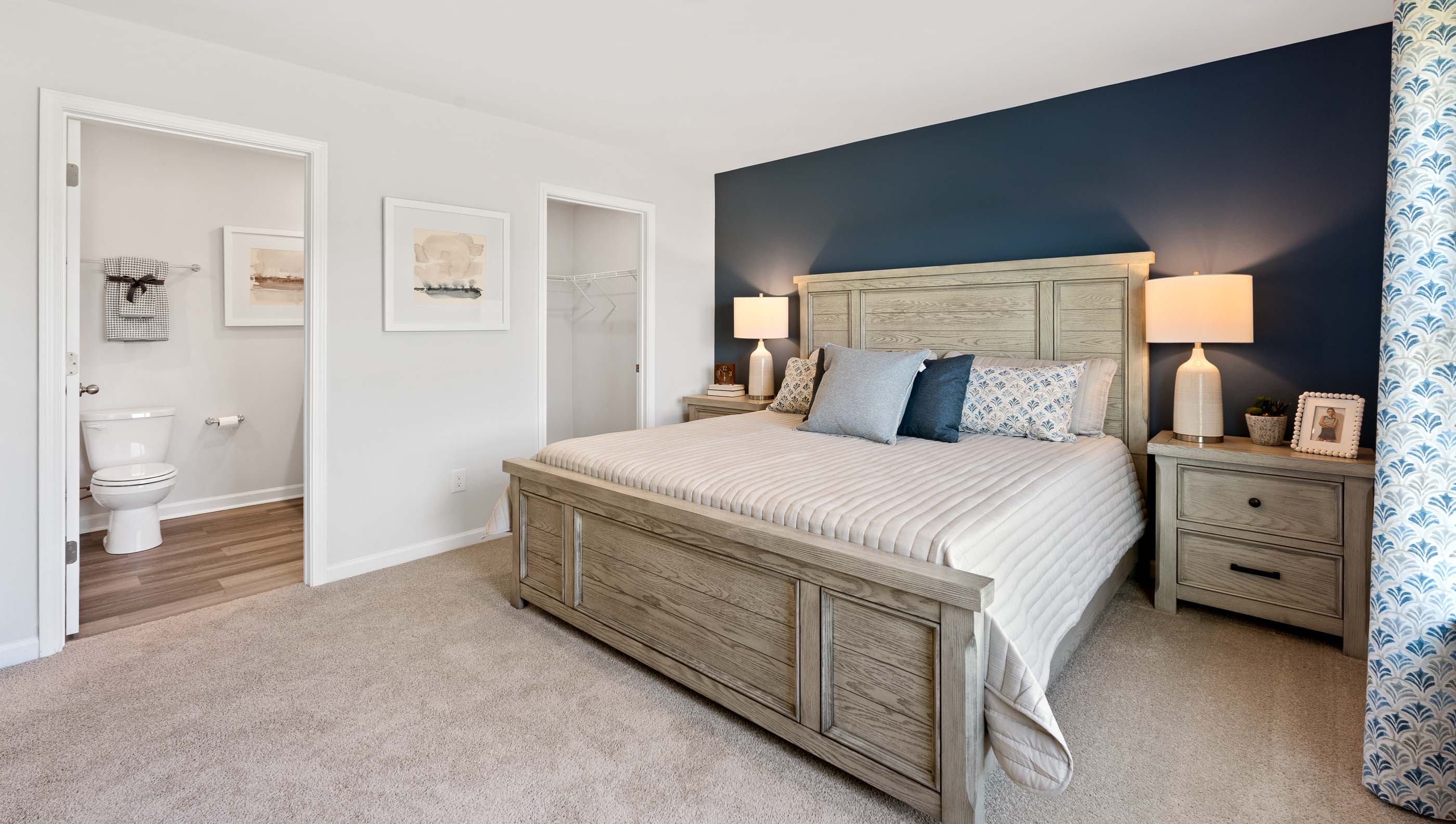 Primary bedroom with carpet and window.