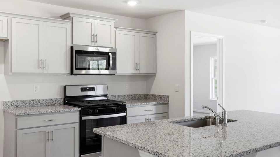 Kitchen with island and quartz counter tops.