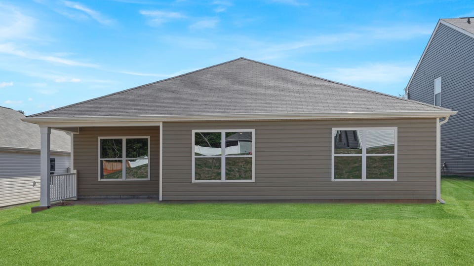 Back exterior of home with large backyard.