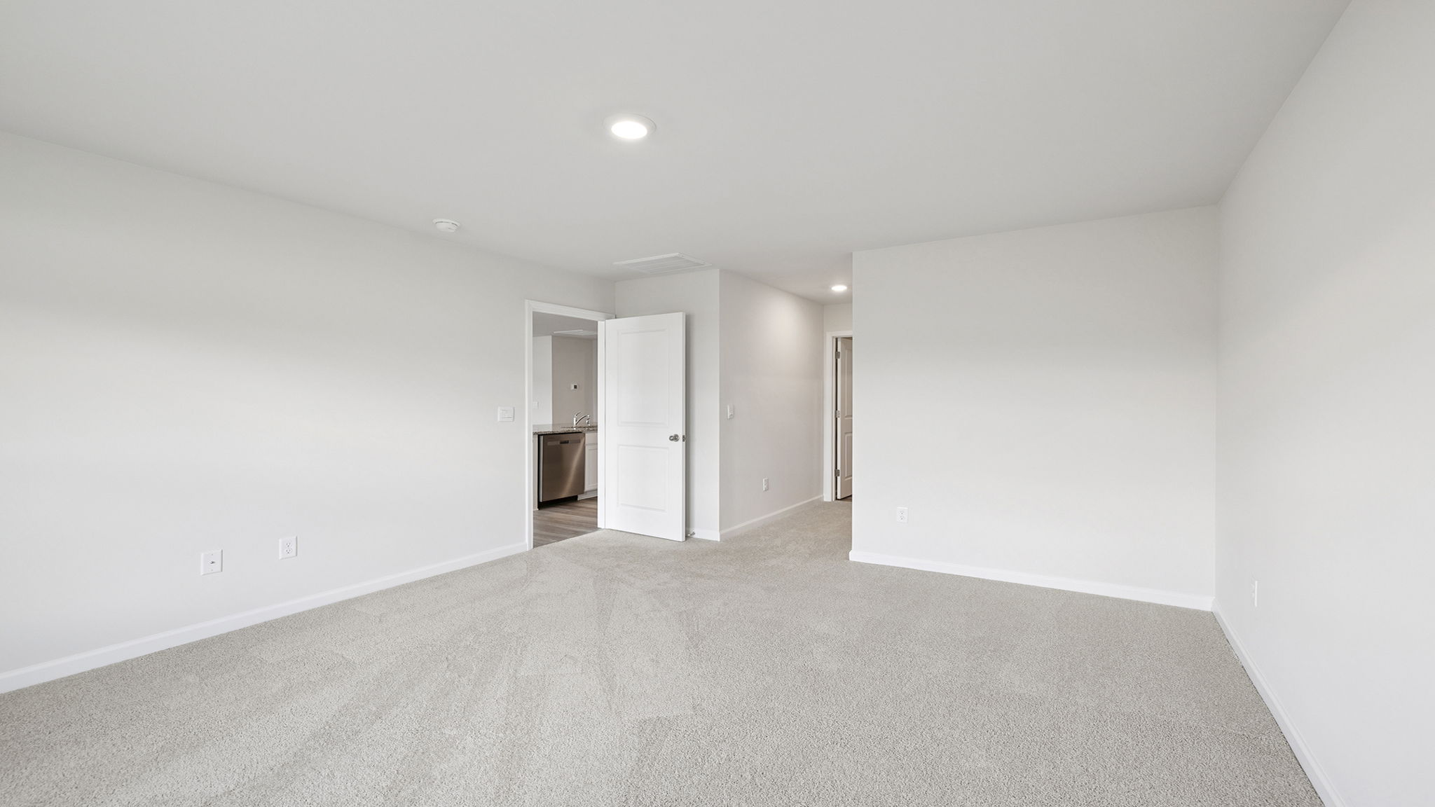 Primary bedroom with large window and carpet.