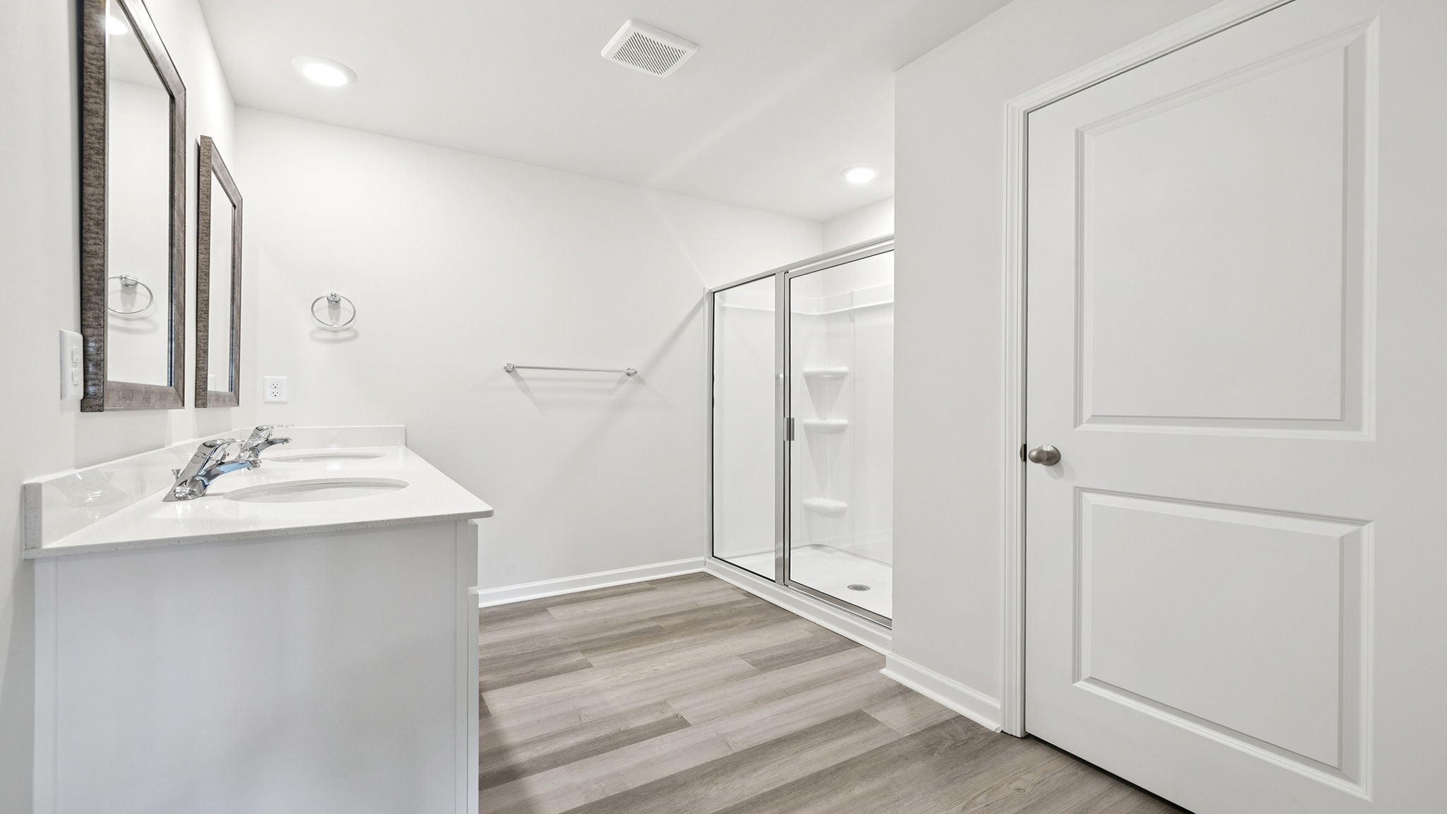 Primary bathroom with dual sink vanity and walk-in shower.
