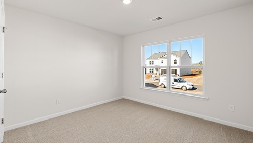 Bedroom with carpet and window.