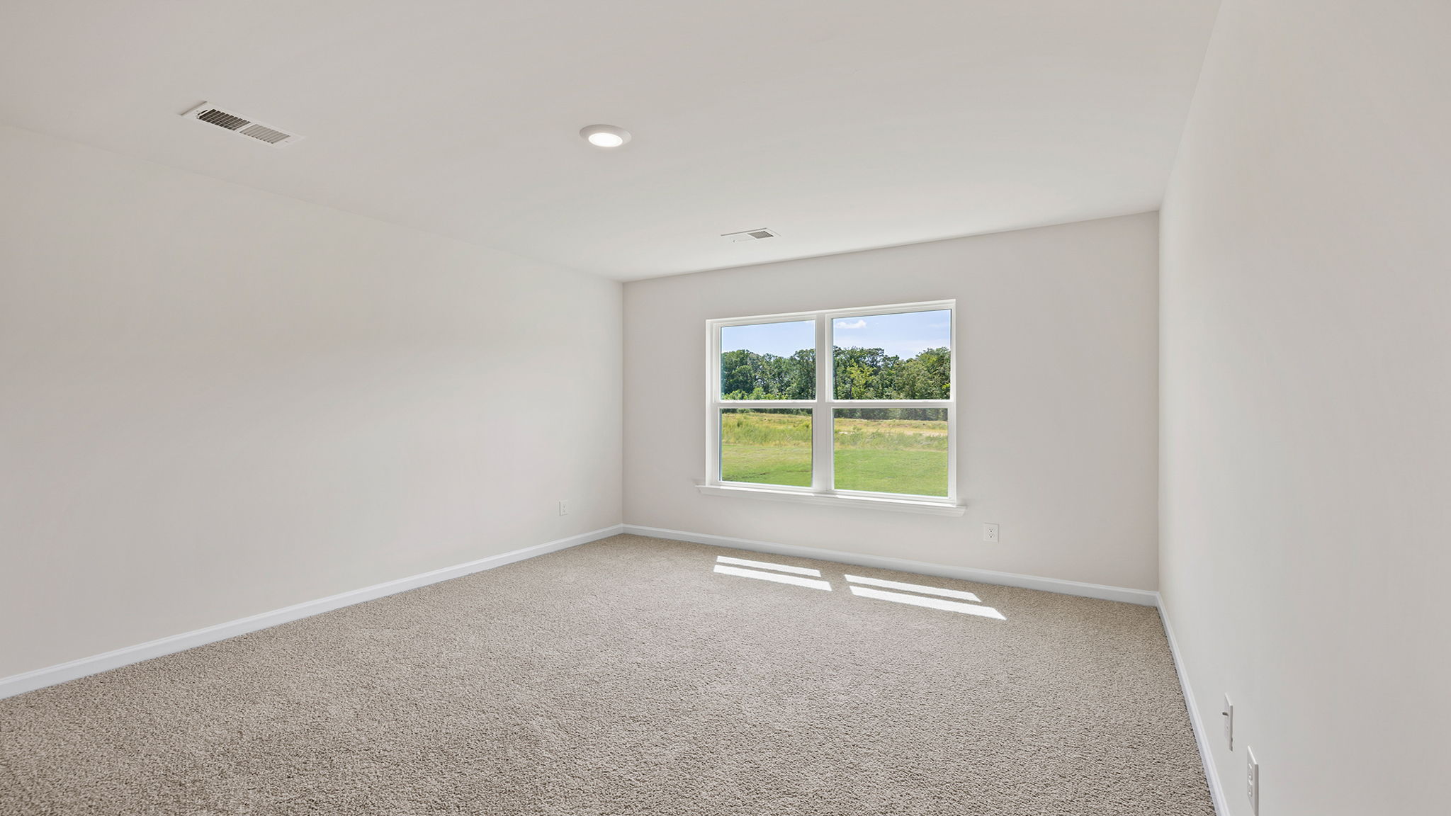Primary bedroom with window and carpet.
