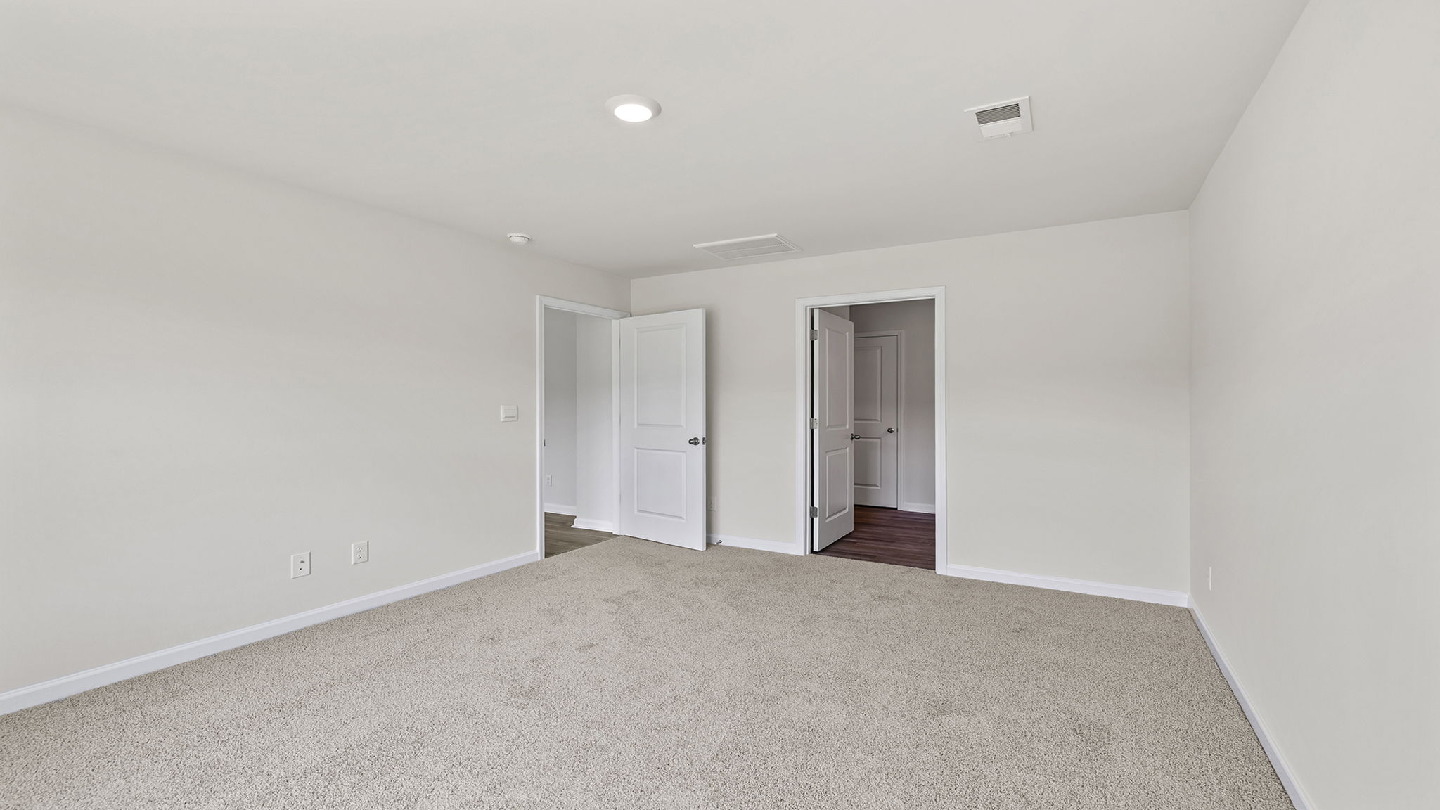 Primary bedroom with window and carpet.
