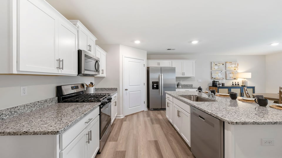 Kitchen and island with quartz countertops and stainless steel appliances.