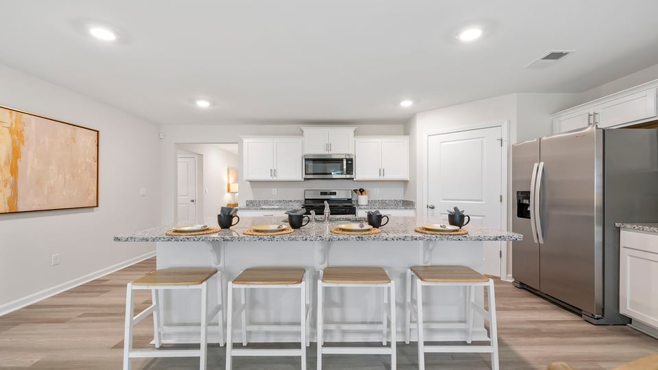 Kitchen and island with quartz countertops and stainless steel appliances.