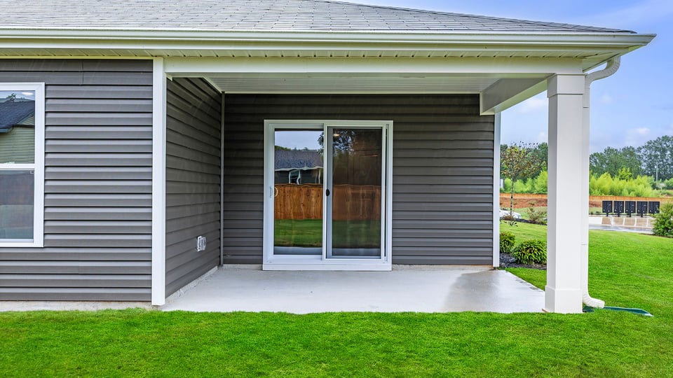 Back exterior with covered patio.