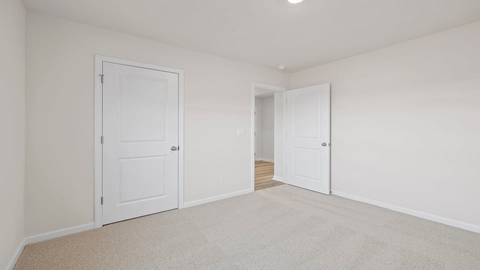 Bedroom with carpet and window.