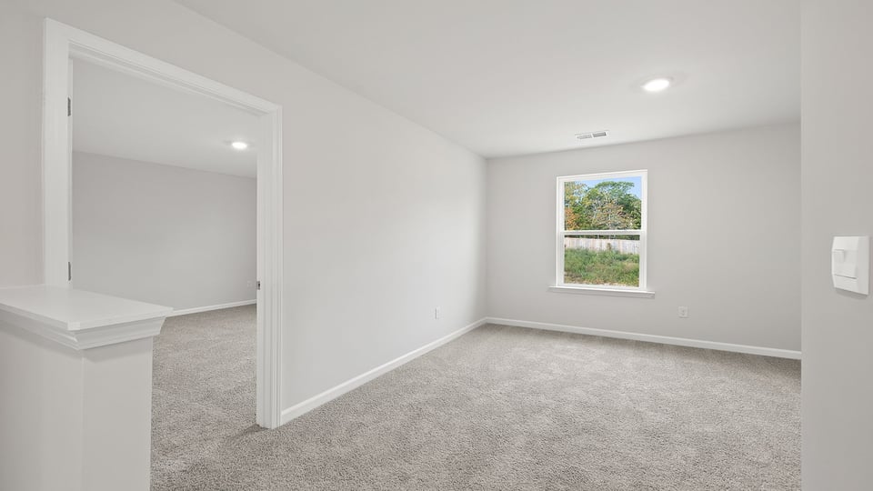 Loft area with carpet and windows.