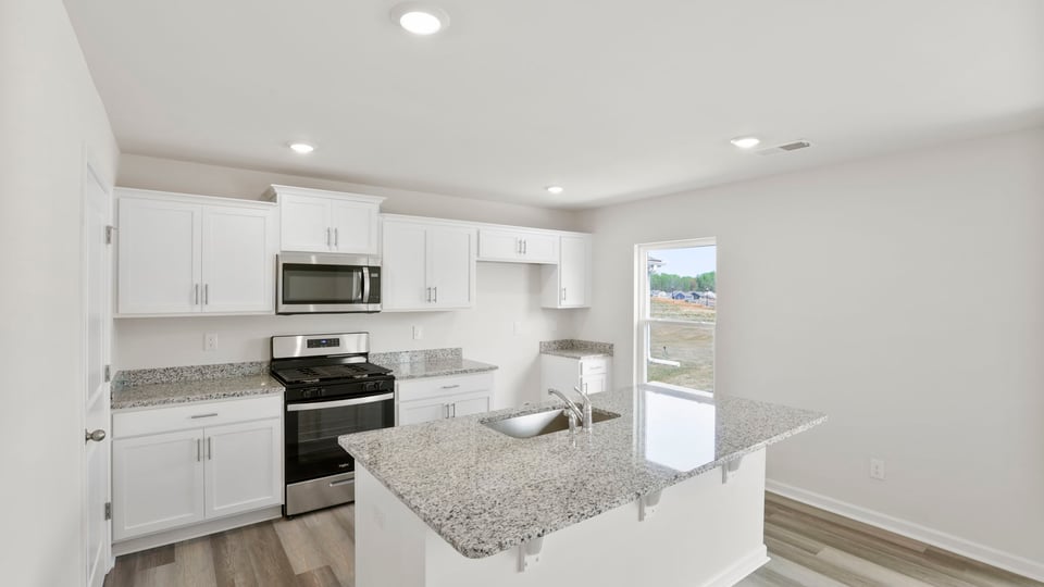 Kitchen and island with stainless steel appliances.
