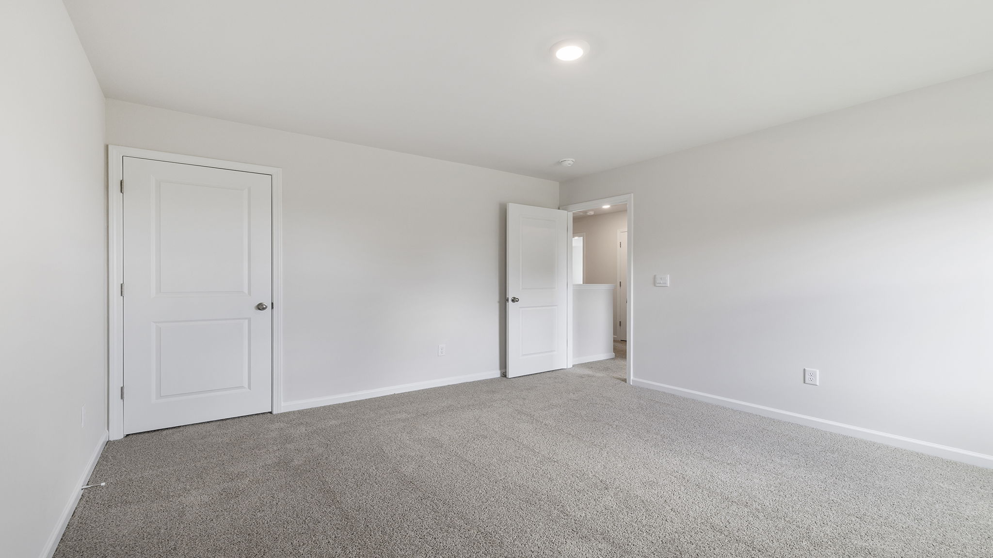 Bedroom with windows and carpet.